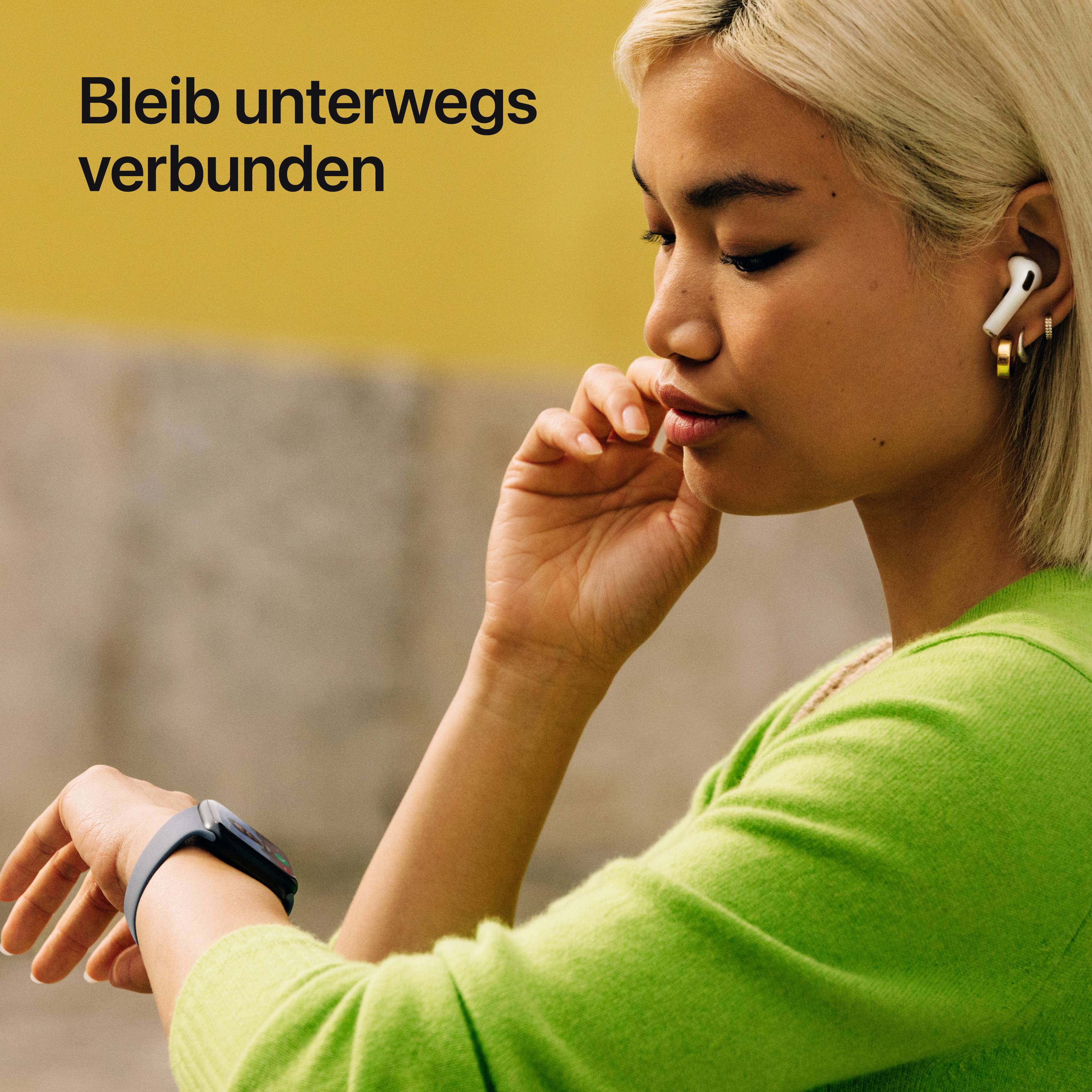 Een persoon met blond haar en groene kleding draagt draadloze oordopjes. Tekst: 'Blijf onderweg verbonden'.