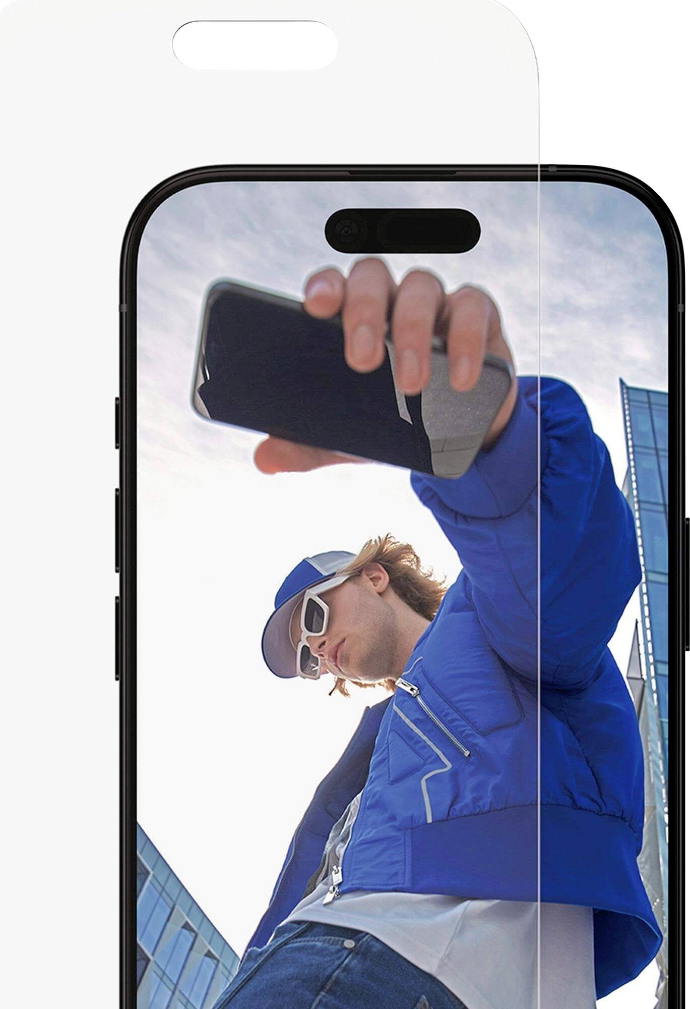 Een persoon in een blauwe jas en zonnebril houdt een smartphone omhoog, met een modern gebouw en blauwe lucht op de achtergrond.