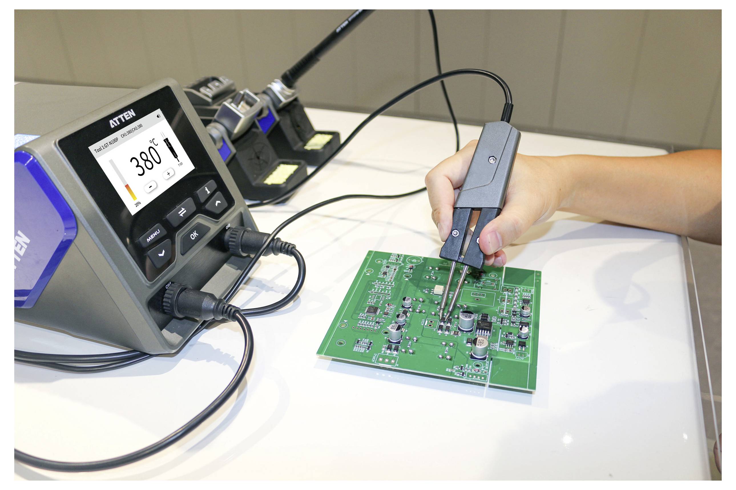 Een persoon gebruikt een soldeerbout op een printplaat, waarbij een digitaal display '380°F' toont. Elektronische componenten zijn zichtbaar op de printplaat.