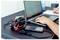 Een persoon die een laptop gebruikt aan een bureau, met een smartphone en een accululader voor een accugereedschap in de buurt.