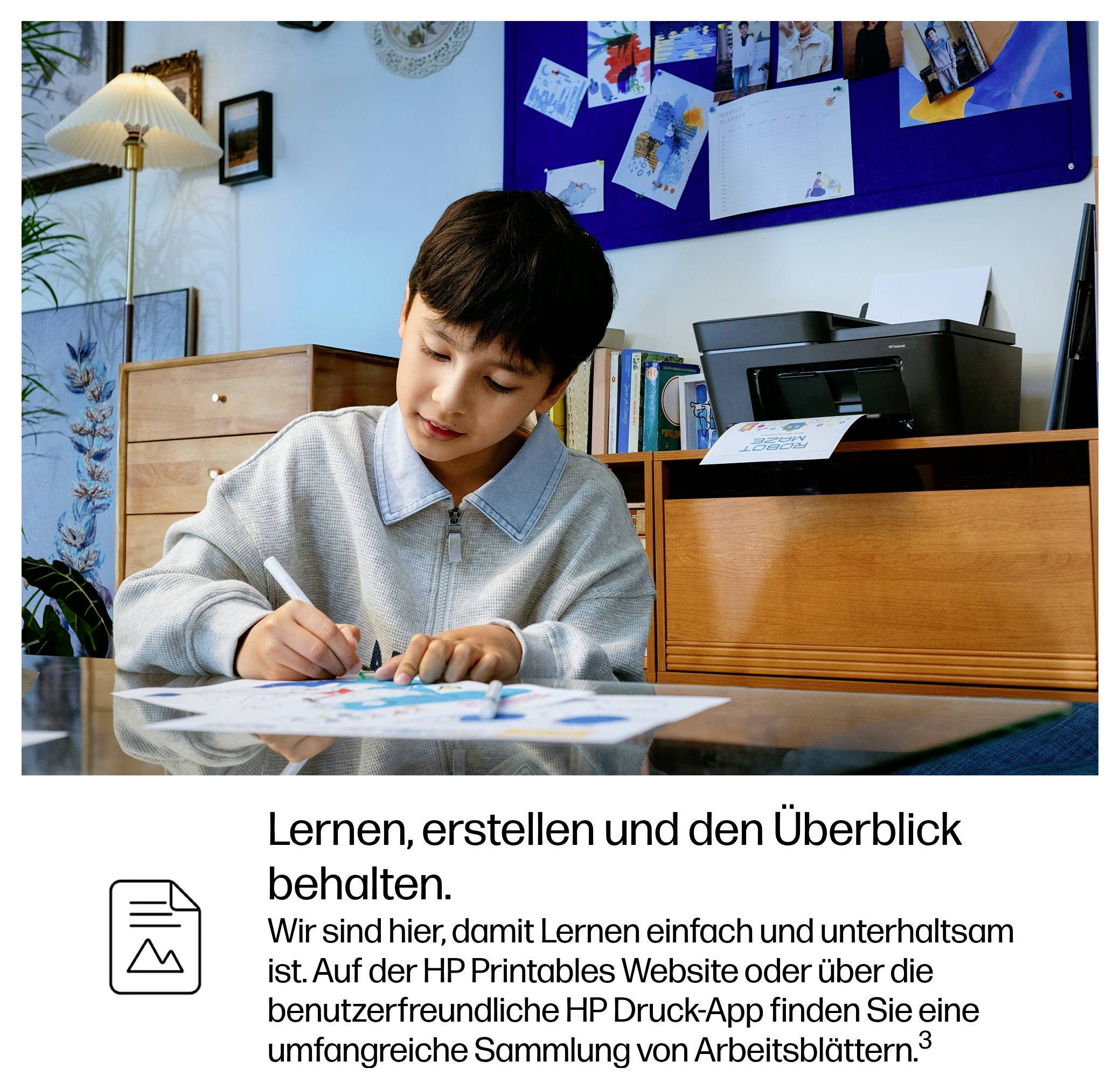 Jongen die aan tafel in een thuisstudiegebied kleurt of schrijft; Duitse tekst hieronder zegt 'Leren, creëren en het overzicht behouden' en vermeldt HP Printables-werkbladen.