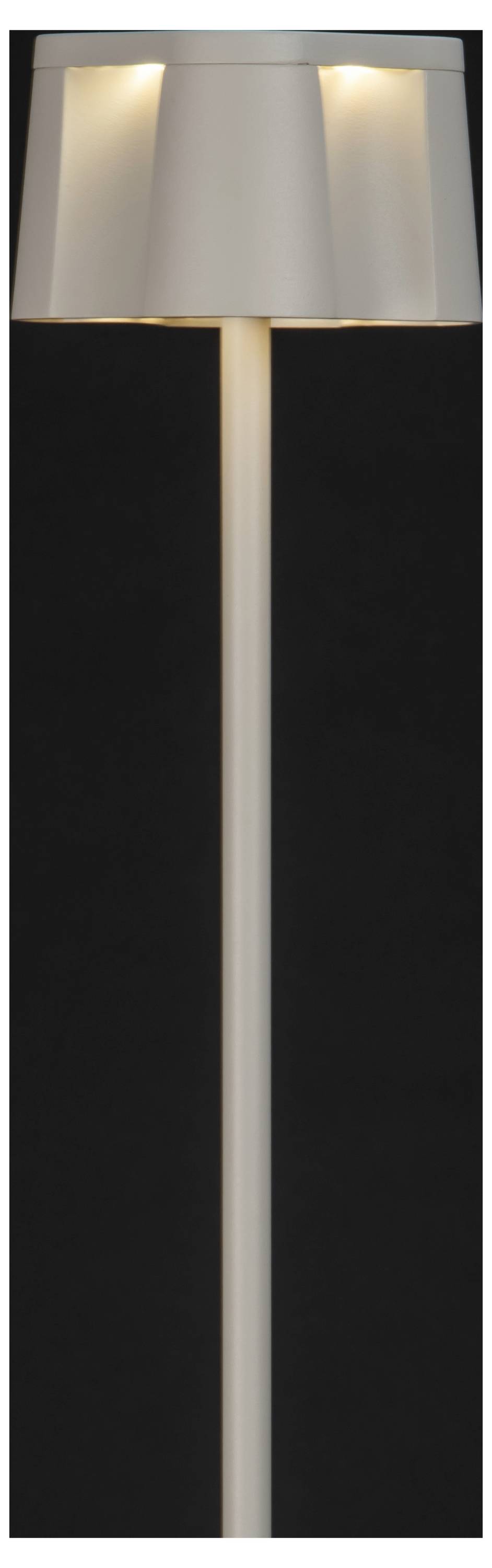 Een moderne vloerlamp met een hoge, slanke voet en een brede, witte lampenkap is verlicht tegen een donkere achtergrond, waarbij zacht licht wordt verspreid.