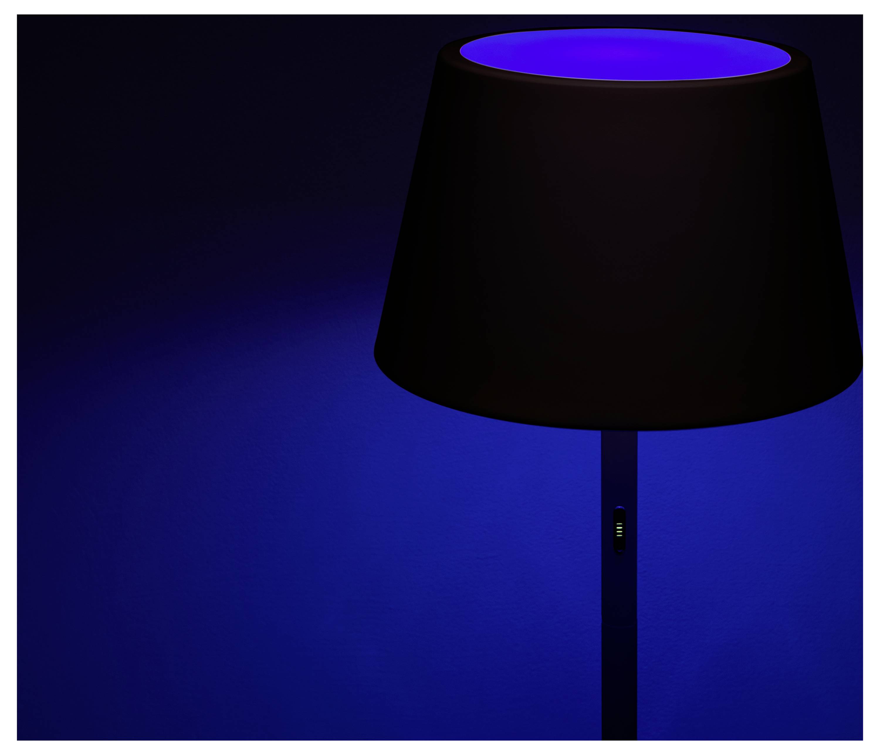 Een vloerlamp straalt een levendig blauw licht uit tegen een donkere achtergrond, waardoor een rustige, moderne sfeer wordt gecreëerd.