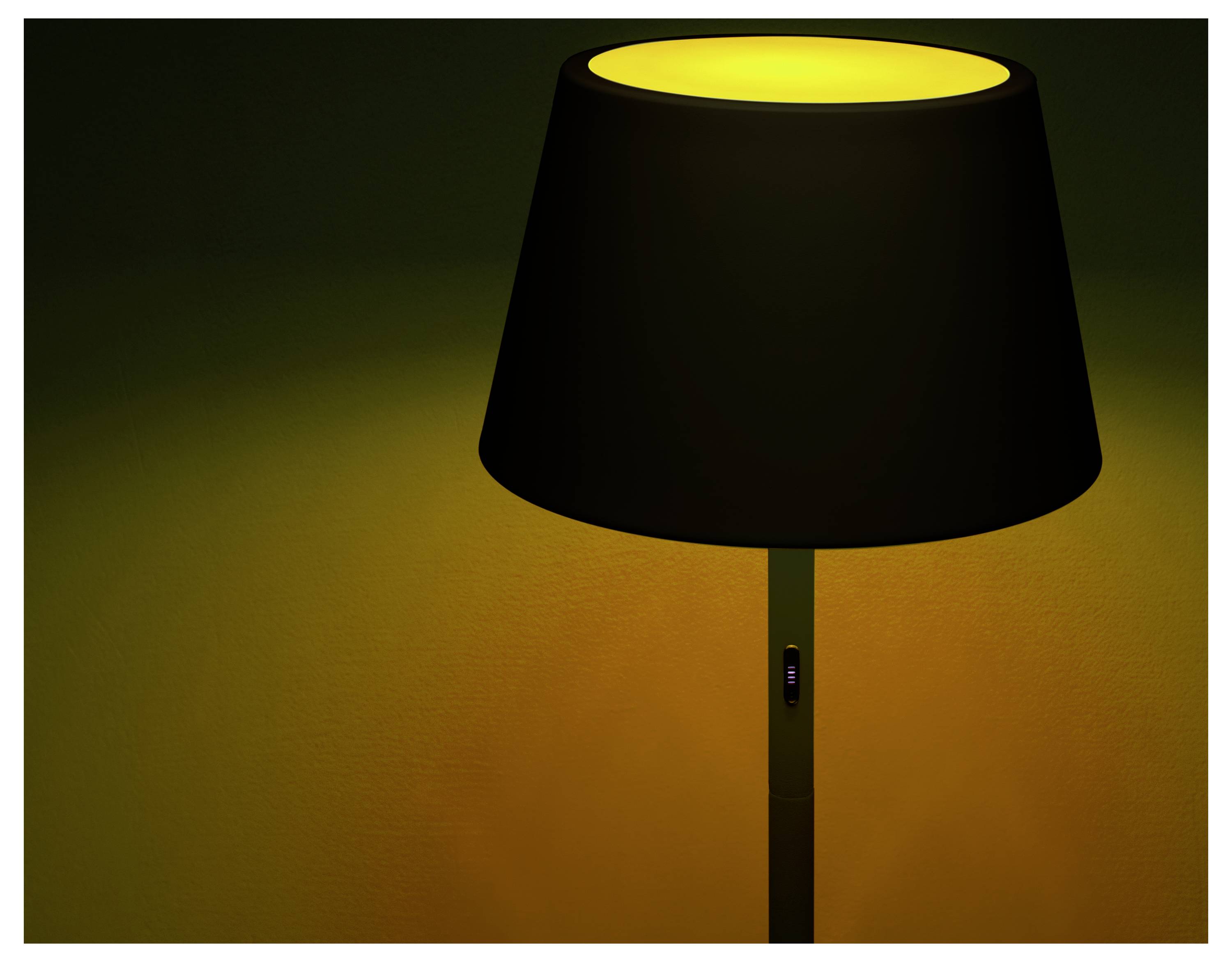 Een vloerlamp met een zwarte kap verspreidt een warm geel licht, waarmee de omringende ruimte wordt verlicht en een gezellige sfeer wordt gecreëerd.