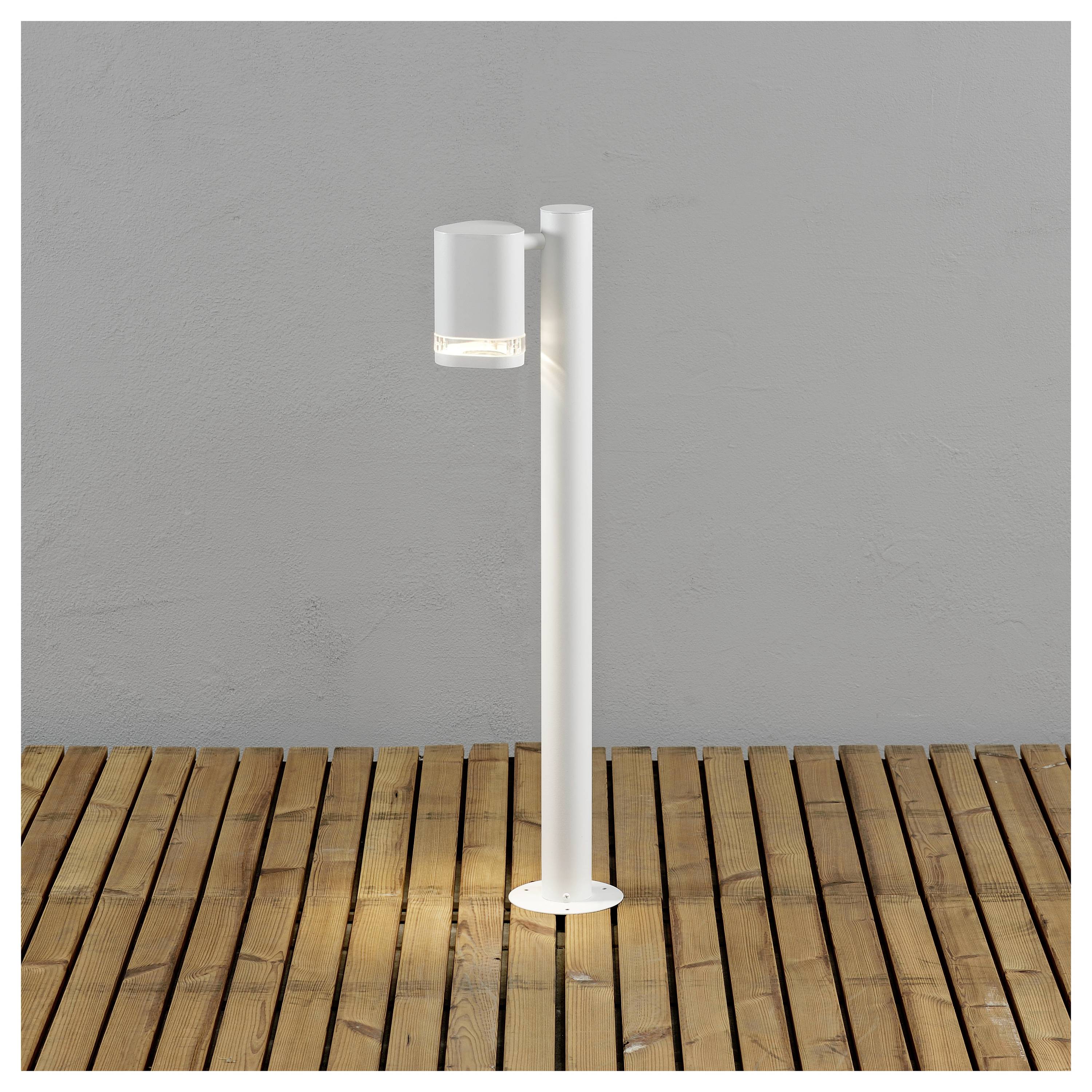 Moderne witte cilindrische buitenlamp op een houten terras, die het gebied verlicht.