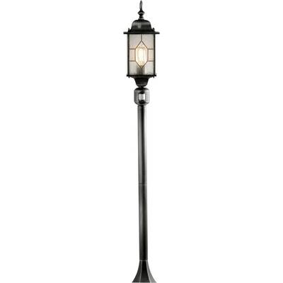 Een hoge, zwarte metalen buitenlantaarnpaal met rechthoekige glazen panelen die een brandende lamp omvatten, met een klassiek lantaarnontwerp.