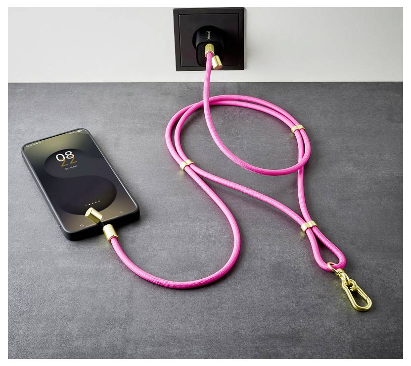 Een smartphone wordt opgeladen op een tafel met behulp van een roze oplaadkabel die is aangesloten op een stopcontact.