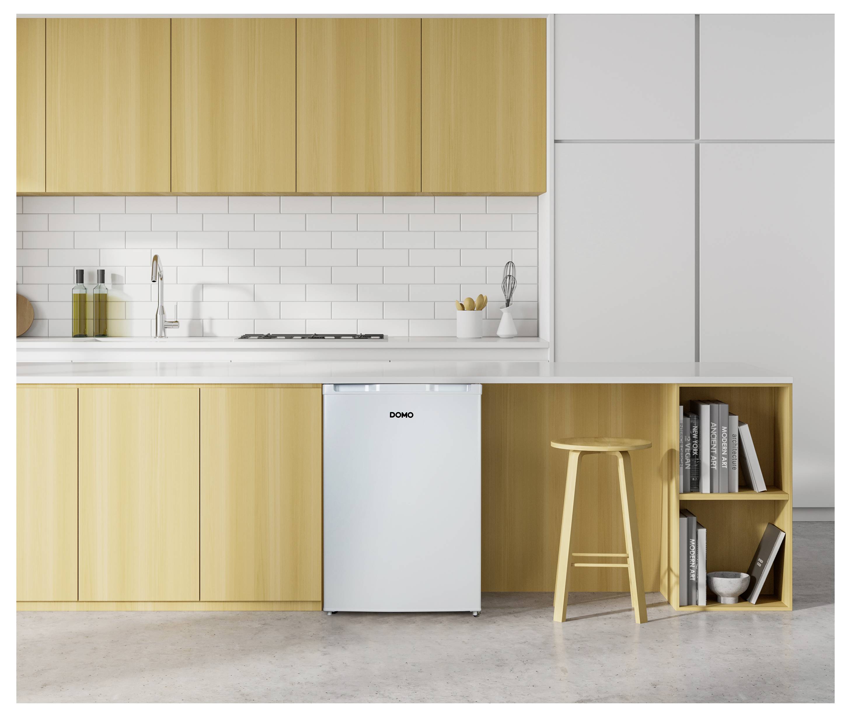 Een moderne keuken met lichthouten keukenkastjes, een achterwand van witte metrotegels en een kleine witte koelkast onder het aanrecht naast een houten kruk.