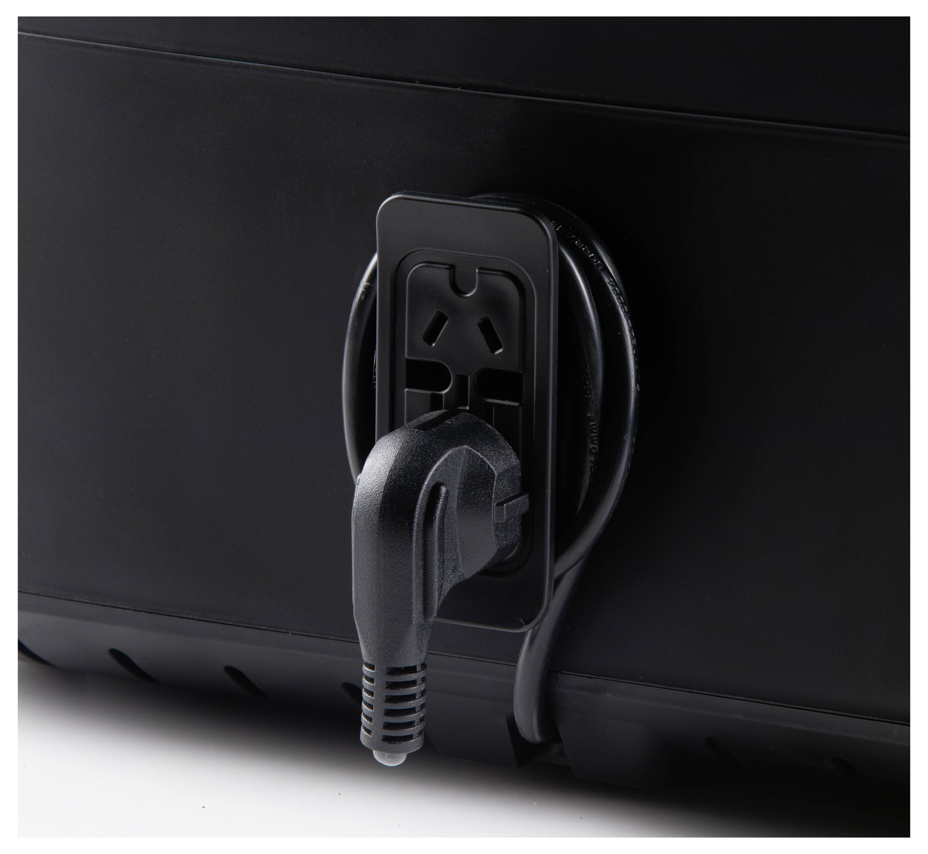 Een zwarte elektrische stekker wordt in een bijpassende contactdoos gestoken, gepositioneerd aan de zijkant van een donker gekleurd apparaat.