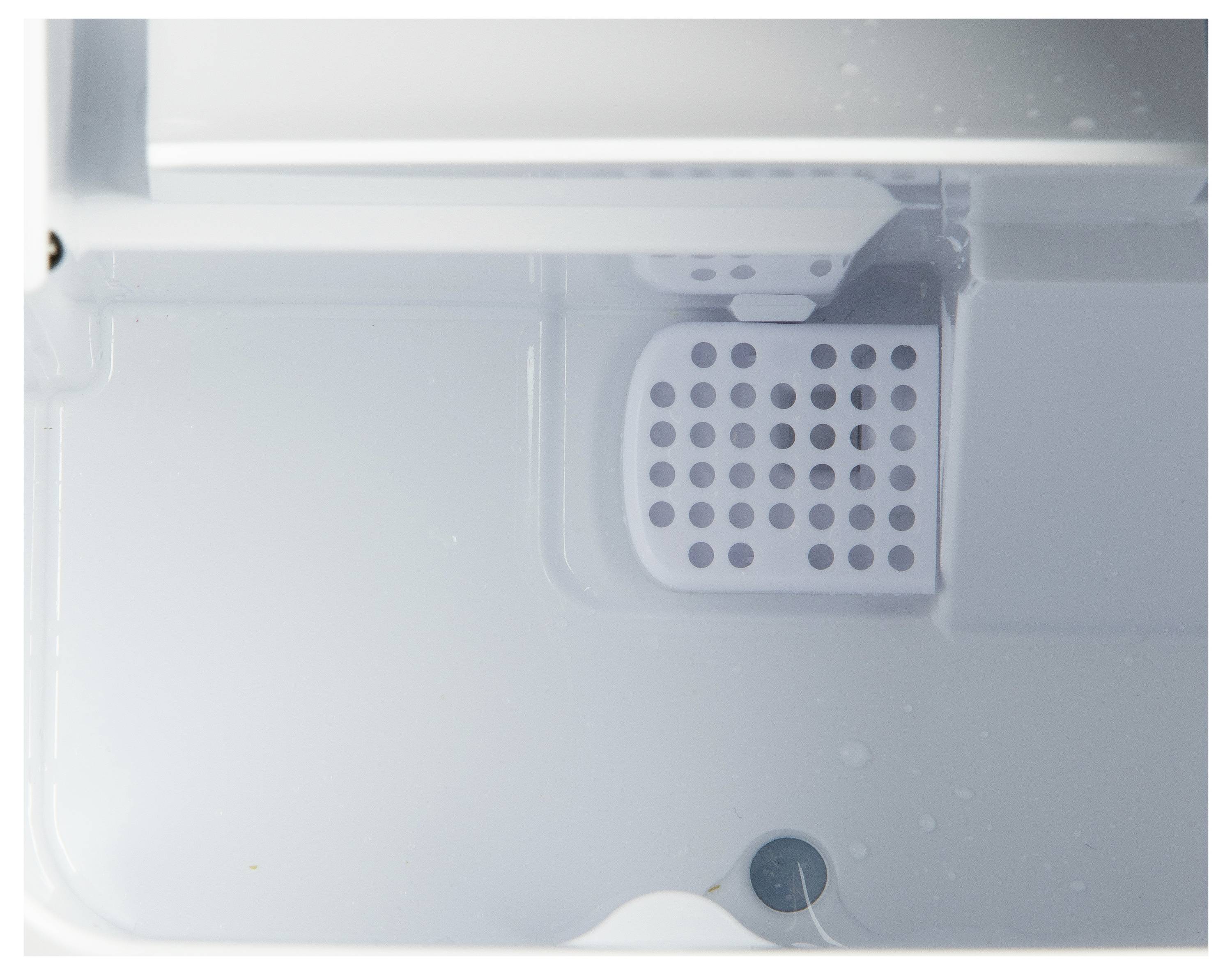 Een lege ijsblokjesvorm binnenin een witte koelvriescompartiment, met een geperforeerde sectie voor ijsvorming en een signaal-LED.