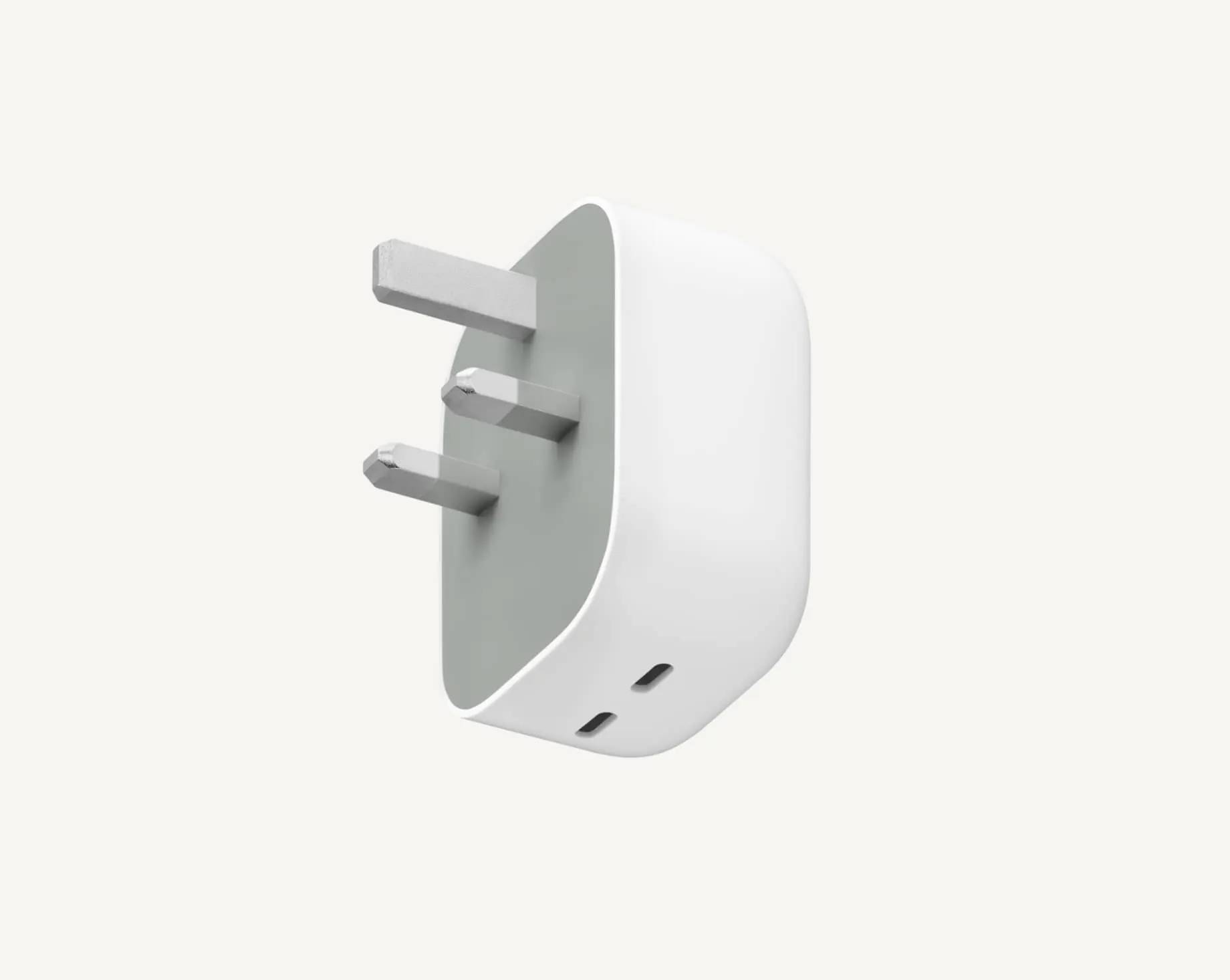 Witte en grijze driepins elektrische stekkeradapter met UK-stijl pennen op een effen achtergrond.