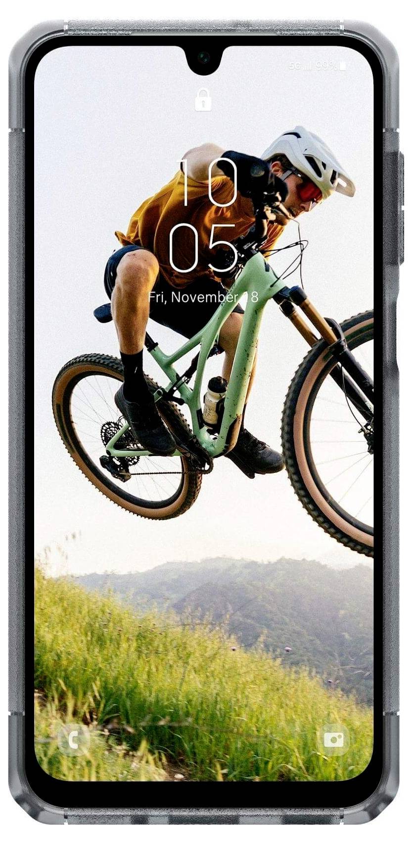 Fietser in de lucht die een sprong maakt op een mountainbike, met een schilderachtige achtergrond, weergegeven op het scherm van een smartphone.