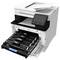 Een witte multifunctionele printer met zijn frontpaneel geopend om vier tonercartridges te tonen. Een stapel papier is bovenaan geladen.