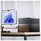 Een moderne computeropstelling op een houten bureau met een kubevormige zwarte pc-behuizing met houten accenten en een monitor waarop een blauw abstract patroon wordt weergegeven.