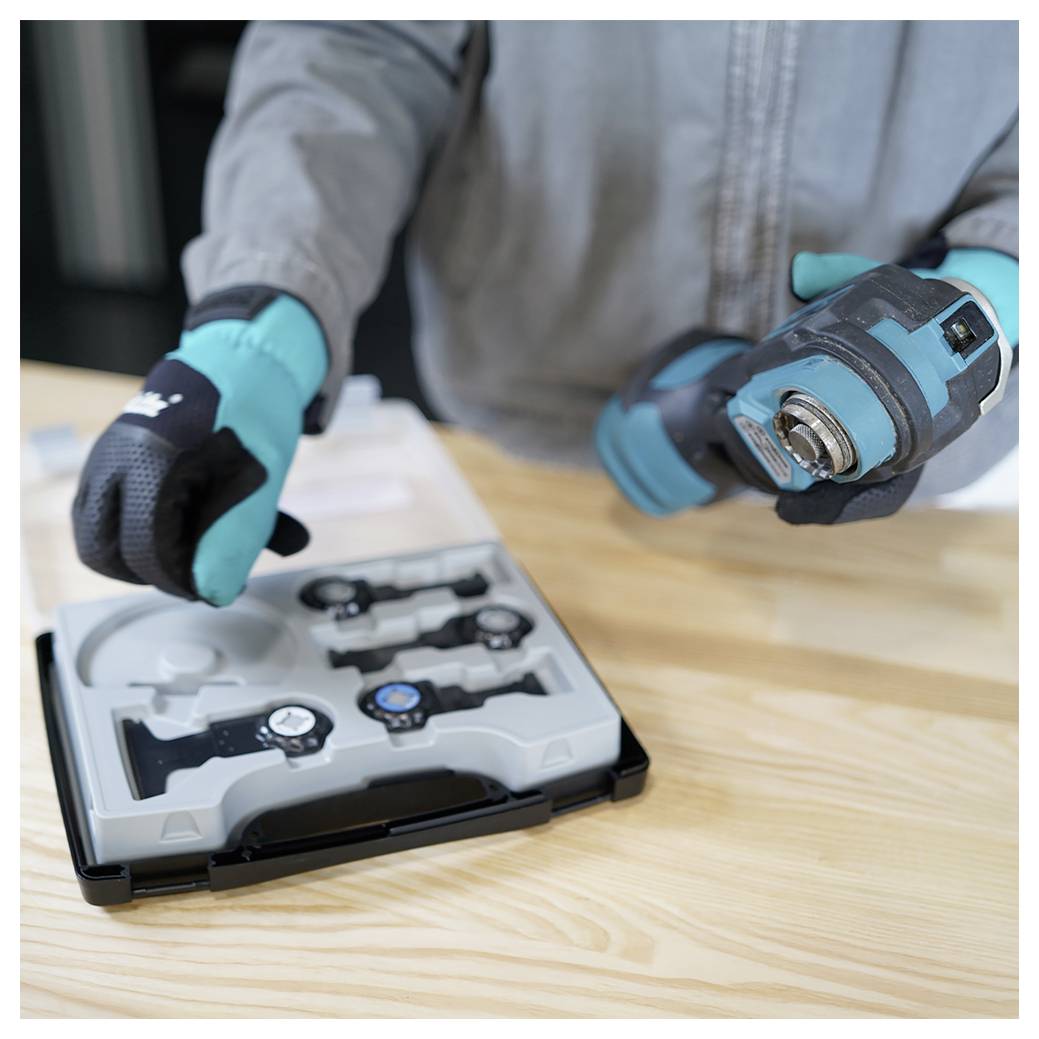 Persoon met tealgekleurde handschoenen die een elektrisch gereedschap gebruikt om toegang te krijgen tot een horlogeherstellingskit op een houten oppervlak.