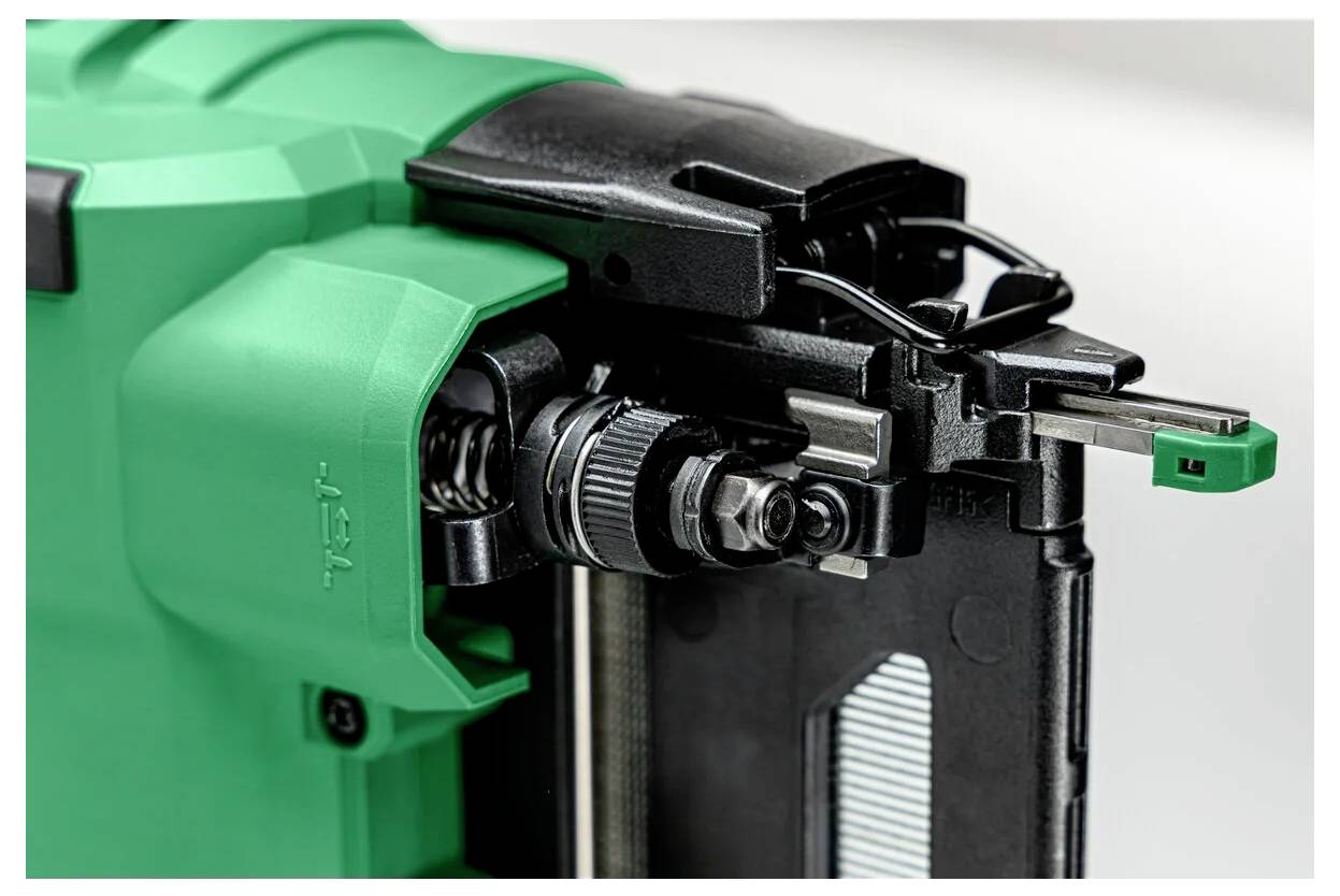 Close-up van een groen en zwart mechanisch apparaat dat gedetailleerde onderdelen toont, waarschijnlijk deel uitmakend van een gereedschap of machine die wordt gebruikt voor precisiehandelingen.