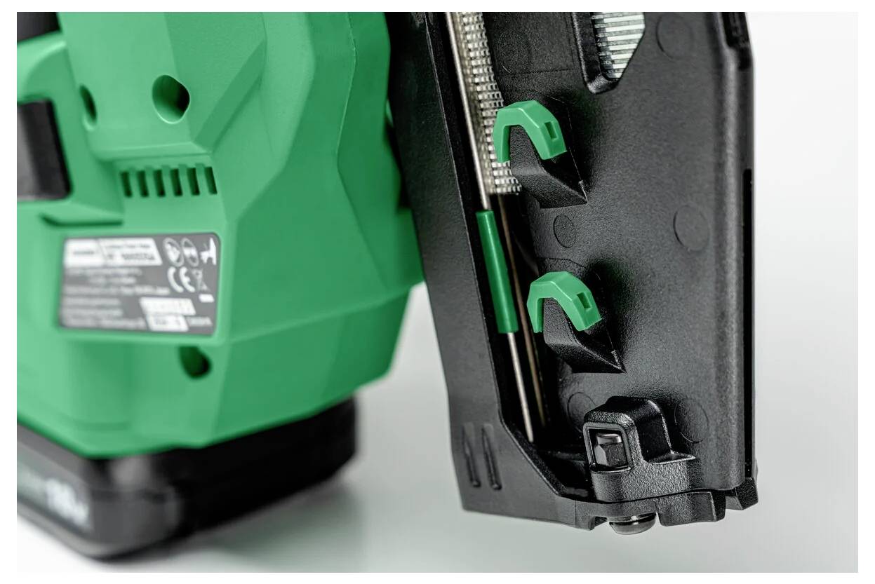 Een groen-zwarte gereedschapsmachine met twee groene klemmen, waarschijnlijk onderdeel van een bevestigings- of snijapparaat, wordt getoond op een lichte ondergrond.