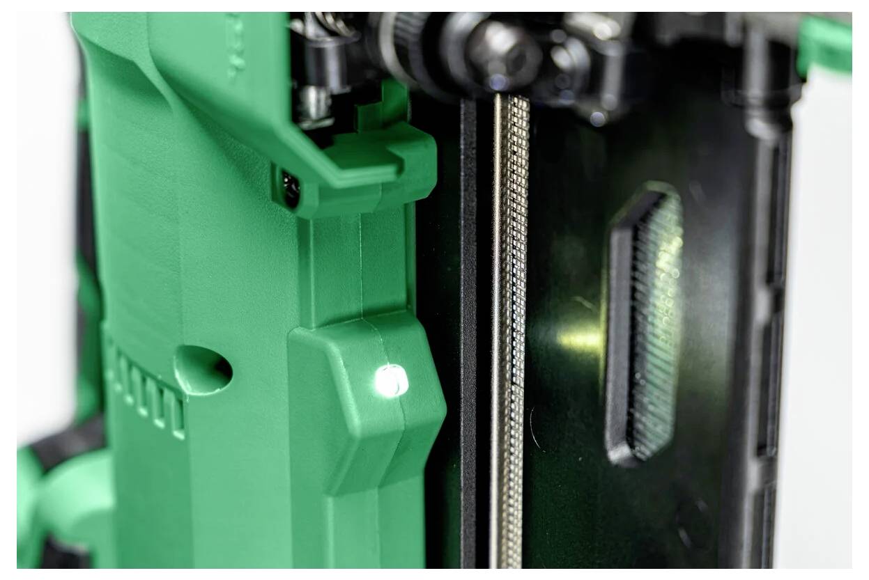 Een close-up van een groen en zwart onderdeel met gestructureerde oppervlakken en complexe mechanische details, waarbij het industriële ontwerp wordt benadrukt.