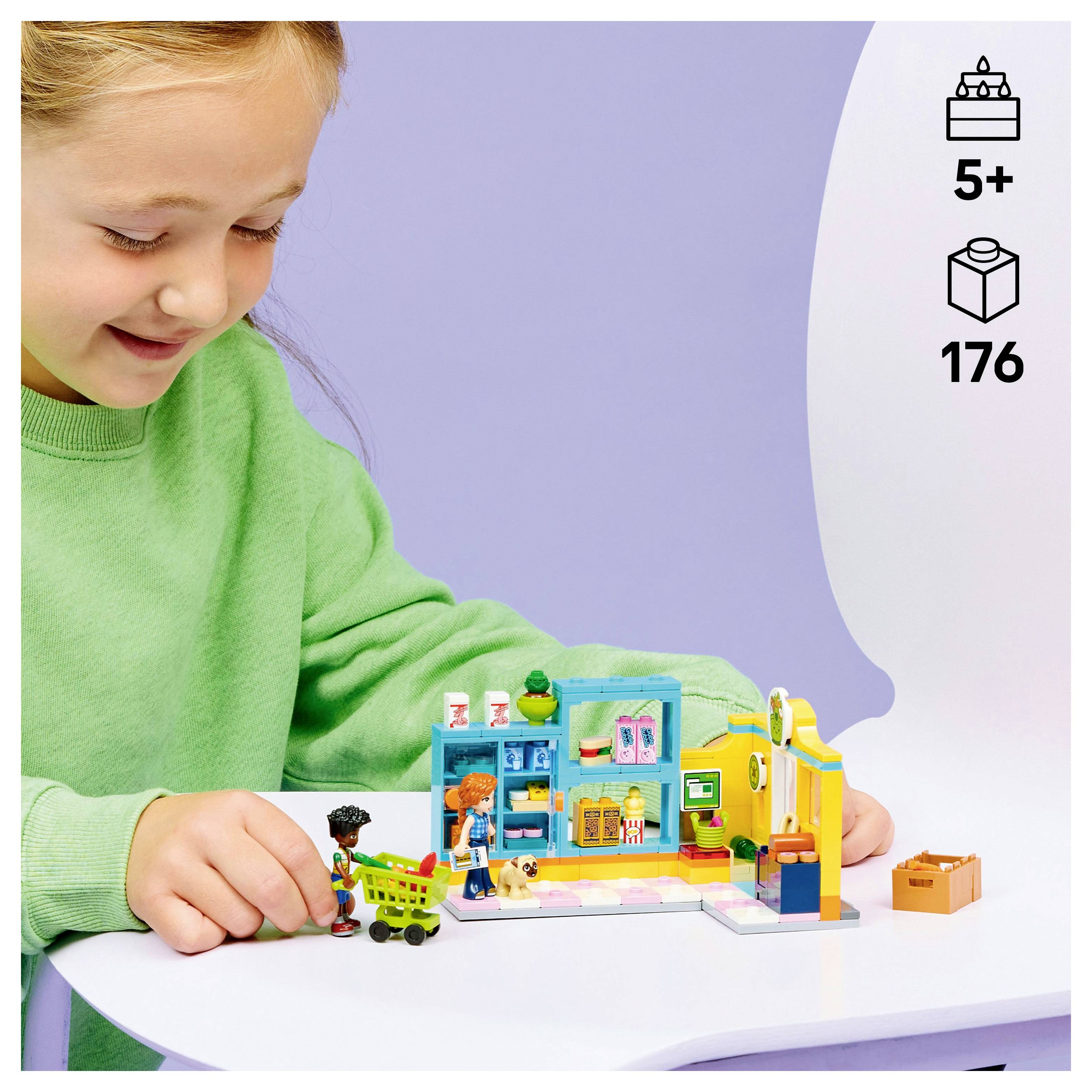 Een kind in een groen shirt speelt met een kleurrijke bouwset. De verpakking geeft aan dat deze geschikt is voor kinderen van 5 jaar en ouder en 176 onderdelen bevat.