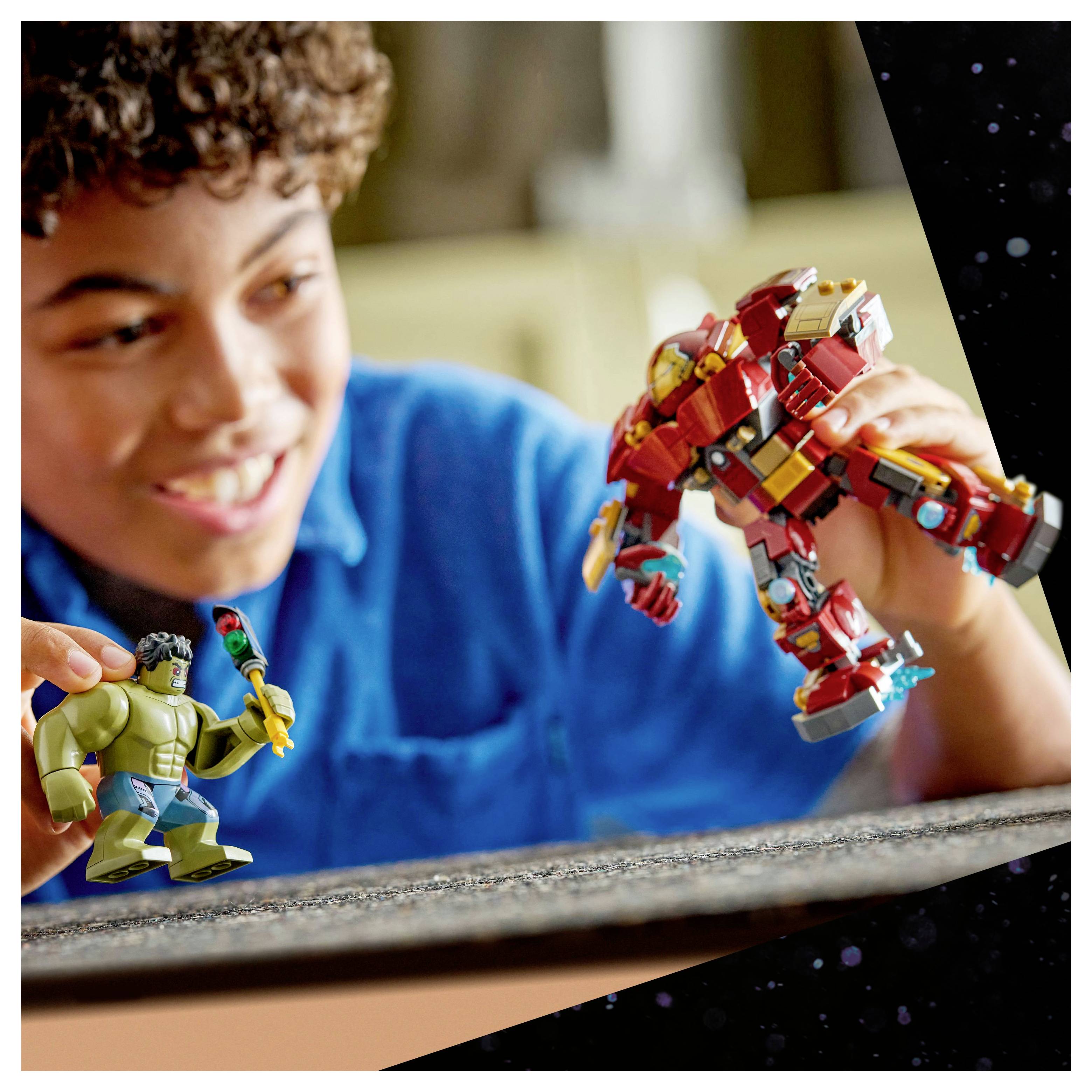 Een kind glimlacht terwijl het speelt met actiefiguren, waarvan één een groene superheld voorstelt en een andere in rode uitrusting, wat fantasiespel suggereert.