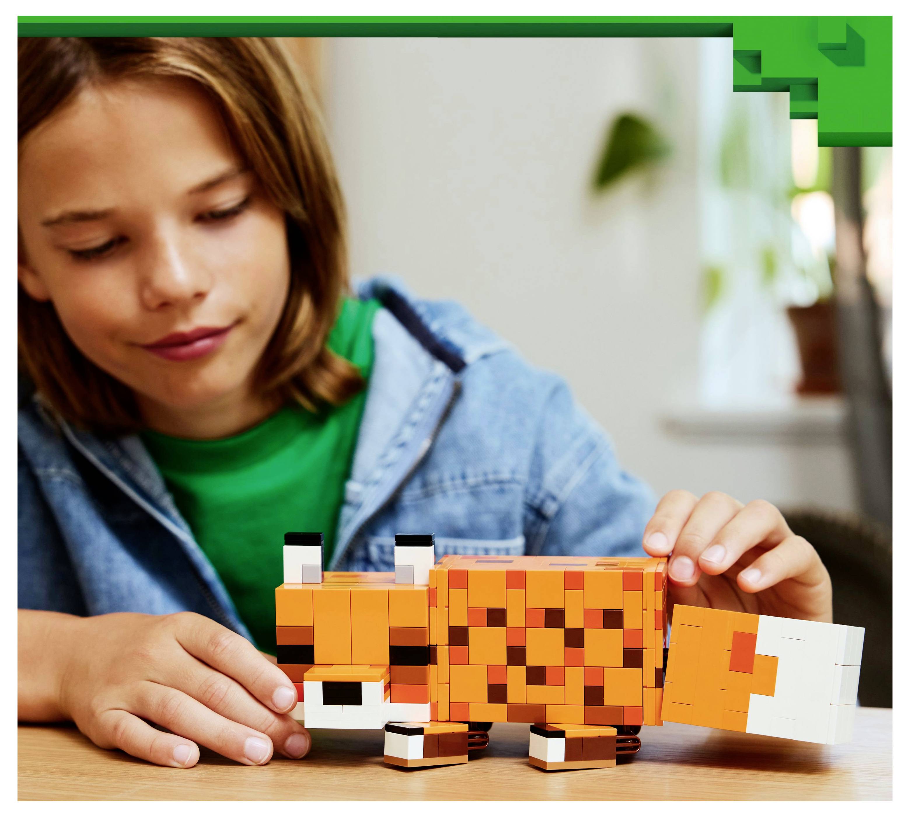 Een kind speelt met een oranje en wit gepixelde vos-speelgoed op een tafel, glimlachend met gefocuste aandacht in een gezellige, goed verlichte ruimte.
