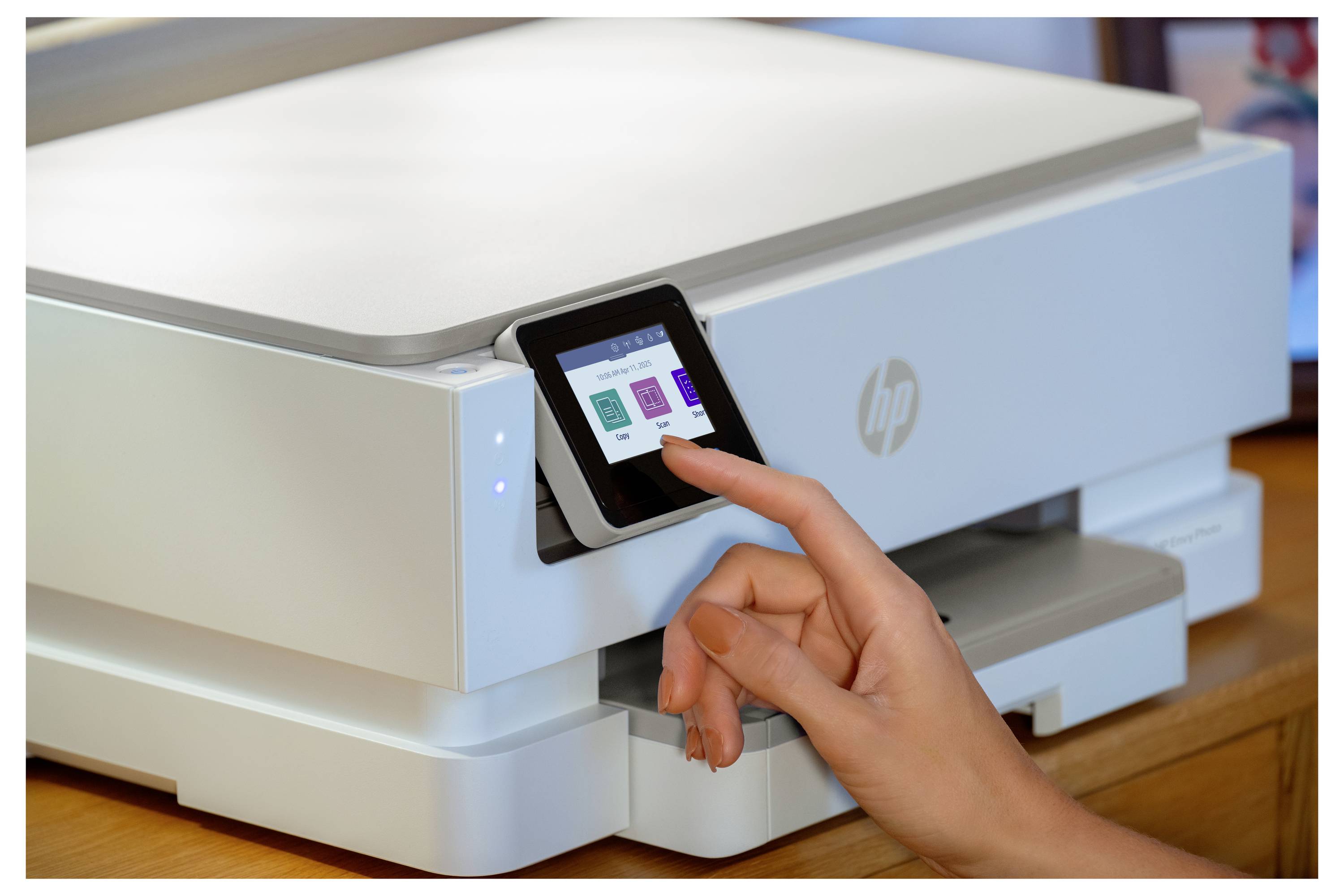 Een persoon bedient het touchscreen-interface van een moderne printer, waarbij hij opties selecteert uit een menu, aan een houten bureau.