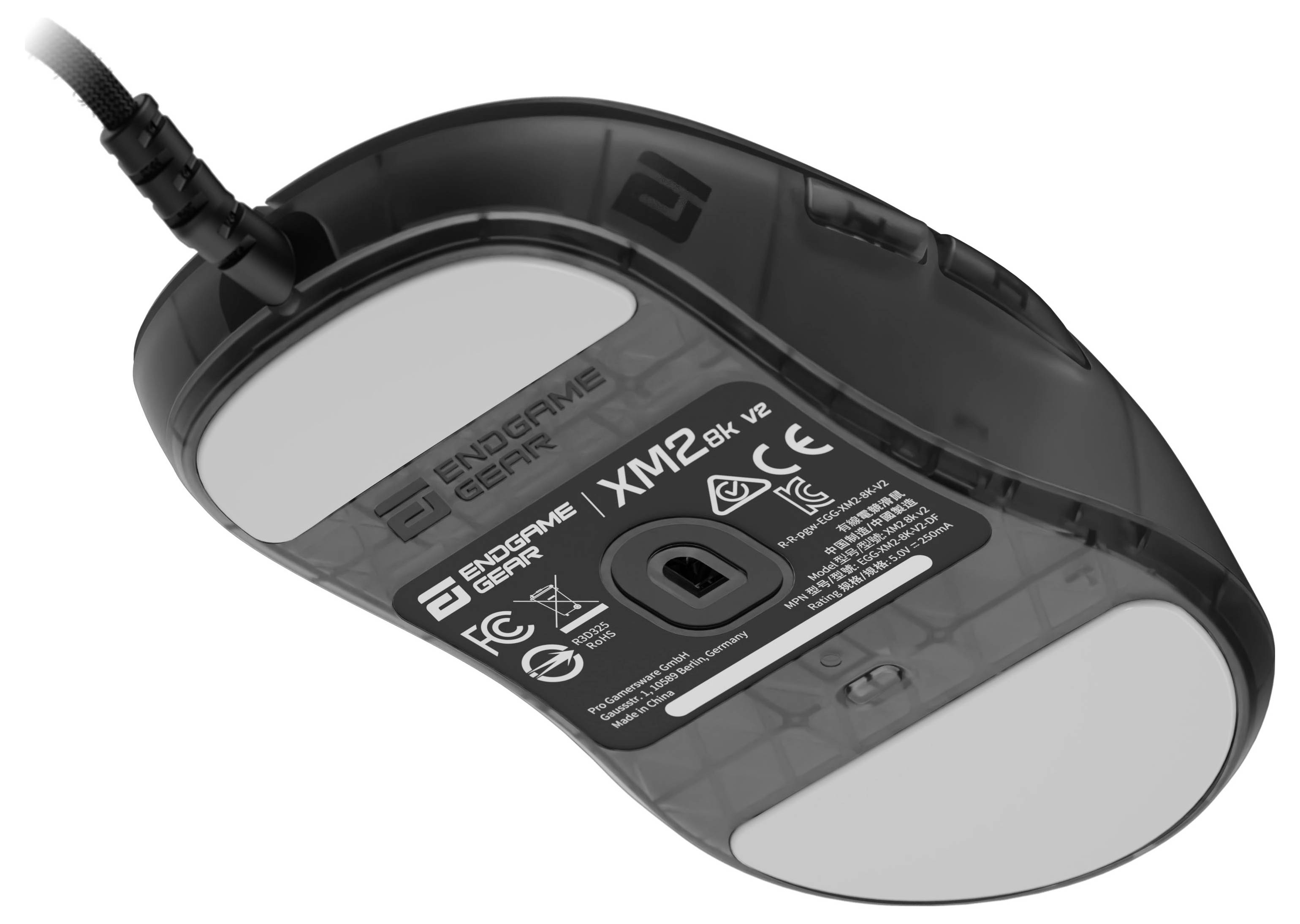 Een zwarte Endgame Gear XM1r muis met witte glijders en certificeringsmarkering, gezien vanaf de onderkant.