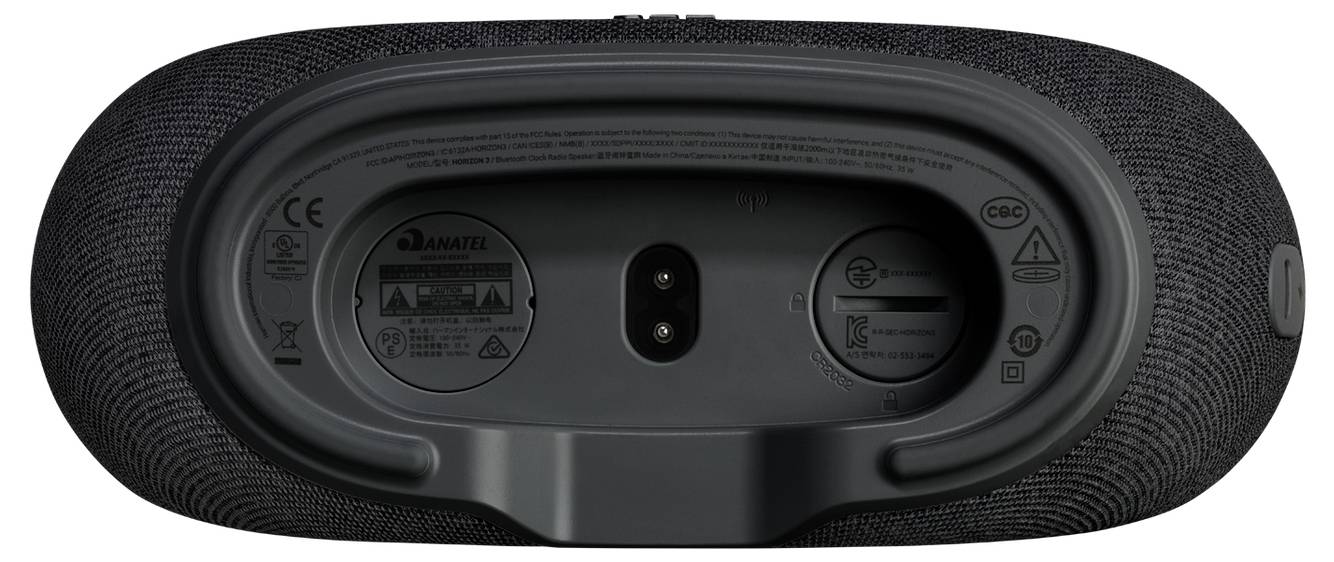 De afbeelding toont de onderkant van een zwarte, ovale draagbare speaker. Het bevat twee ronde gebieden voor opladen en connectiviteit, met pictogrammen en labels eromheen.