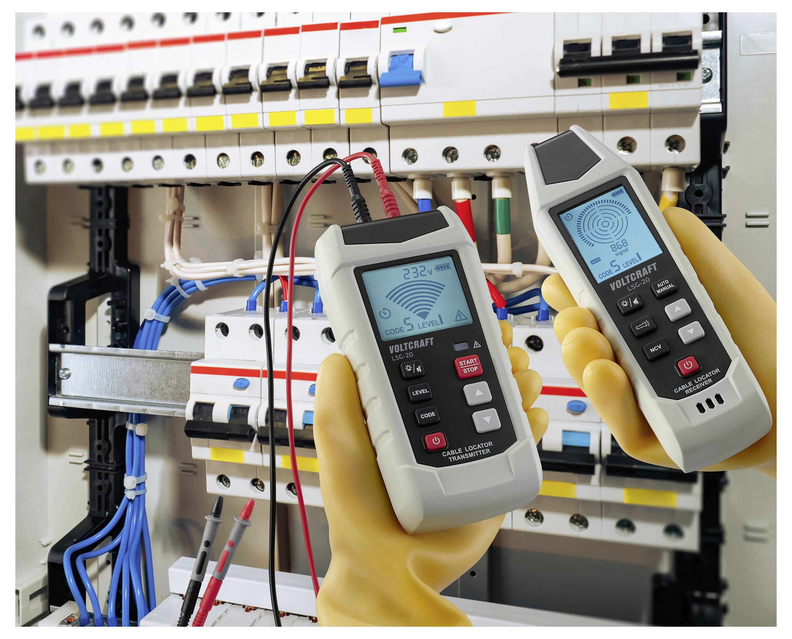Handschoenen dragende handen houden twee digitale multimeters voor een elektrisch paneel, waarin spanningswaarden worden weergegeven als onderdeel van een circuittoetsingsproces.