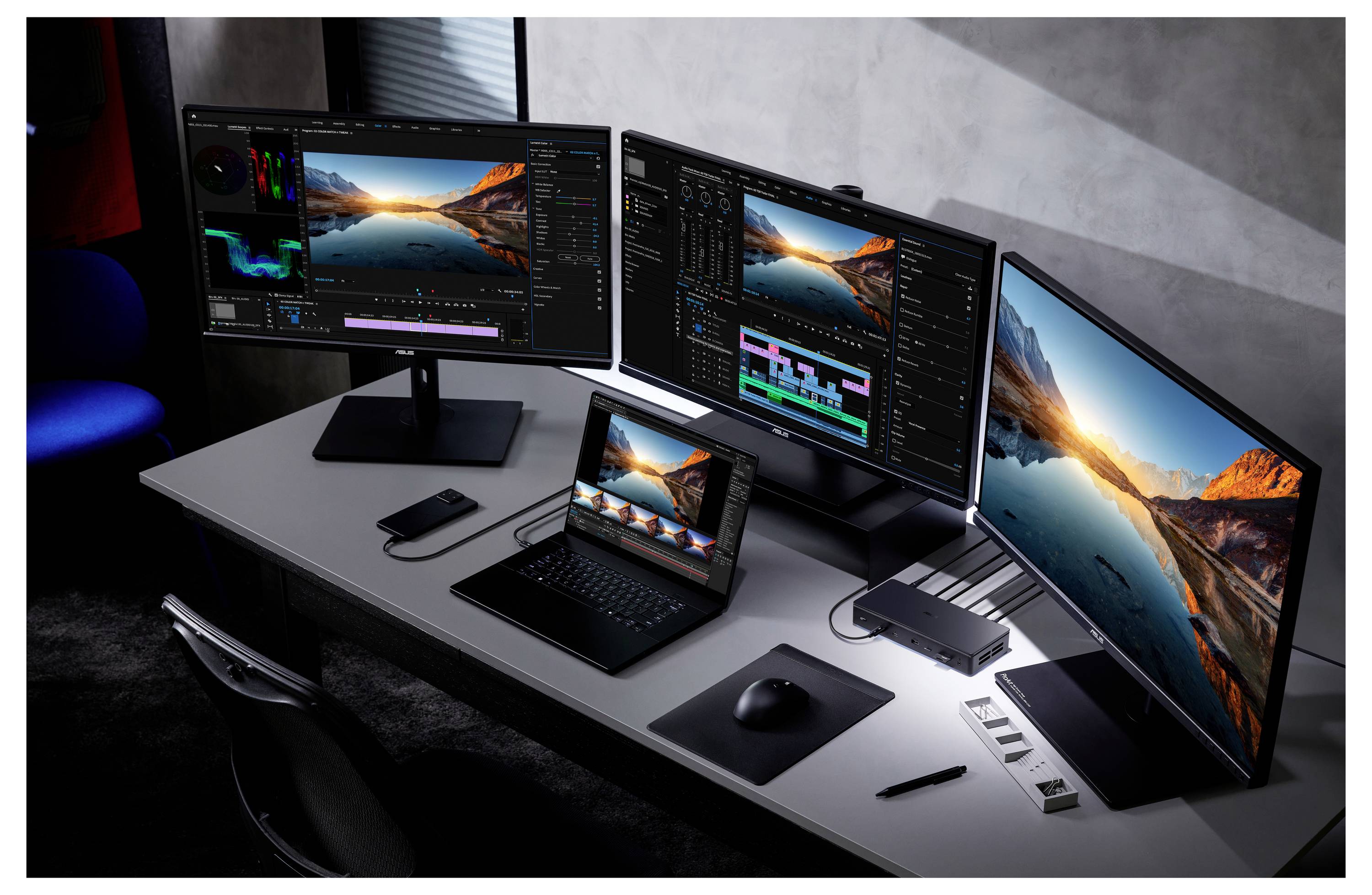 Een bureauopstelling met drie monitoren en een laptop waarop videobewerkingssoftware wordt weergegeven, omringd door verschillende technische accessoires in een donker verlichte ruimte.