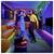 Een man en vrouw dansen energiek in een kleurrijke, moderne woonkamer met heldere, veelkleurige verlichting en stijlvolle decoratie.
