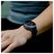 Een close-up van een smartwatch om de pols van iemand waarop een hartslag van 82 slagen per minuut wordt weergegeven, met een band in groen en rood design.