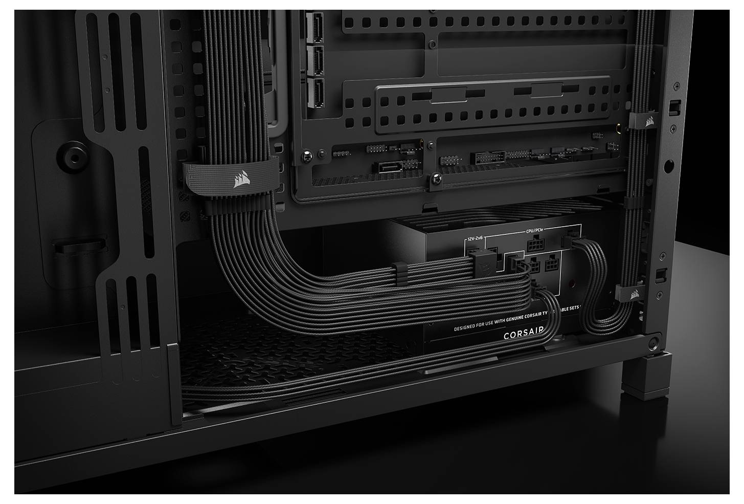 'Close-up van het interieur van een computerbehuizing, met netjes georganiseerde kabels en een Corsair voedingsunit onderaan.'