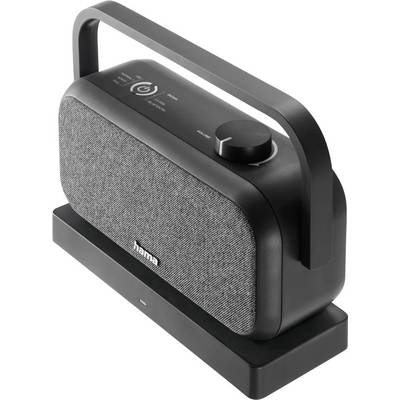 Een draagbare zwarte speaker met een grijze stoffen voorkant, voorzien van een grote volumeknop en bedieningsknoppen bovenop, geplaatst op een dockingstation.