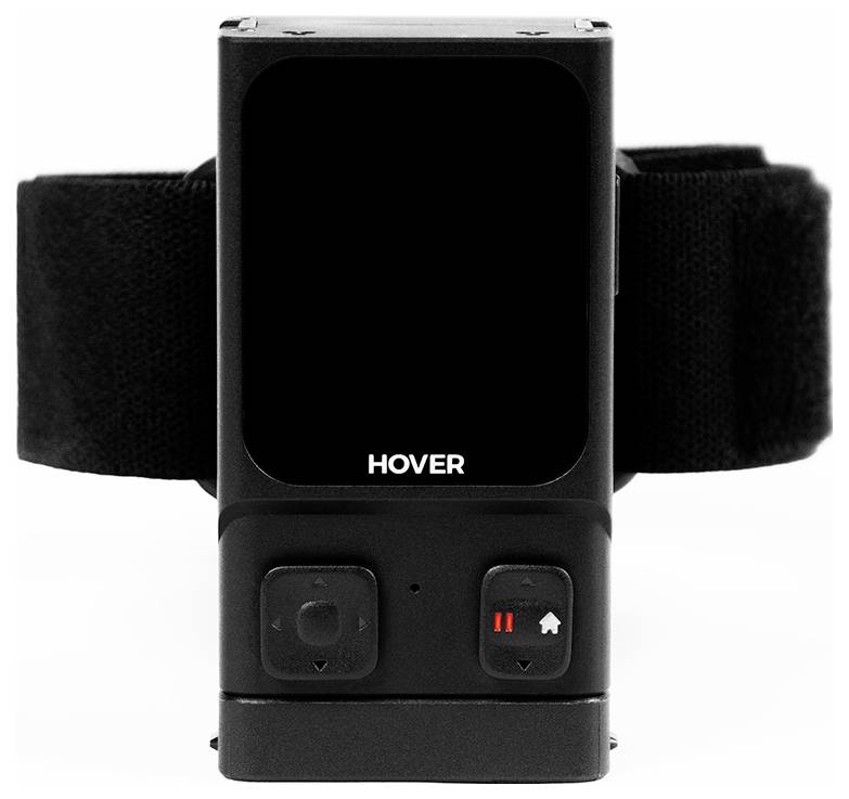 Een zwart apparaat met het label 'HOVER' op de voorkant, voorzien van een scherm en twee knoppen eronder. Het apparaat is bevestigd aan een verstelbare riem.