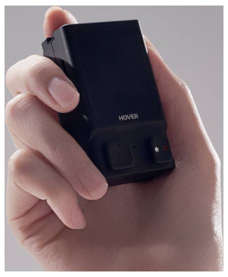 Hand die een klein zwart apparaat vasthoudt met het label 'HOVER', met knoppen aan de voorkant.