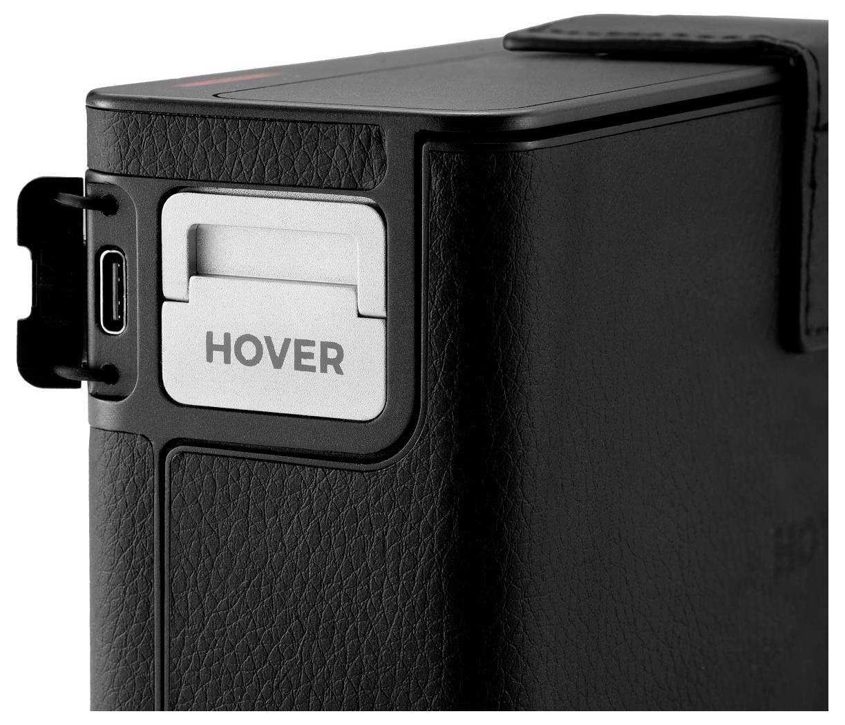 'Hover' tekst op een zwart rechthoekig elektronisch apparaat met een USB-poort aan de zijkant. Apparaat heeft een gestructureerd oppervlak.