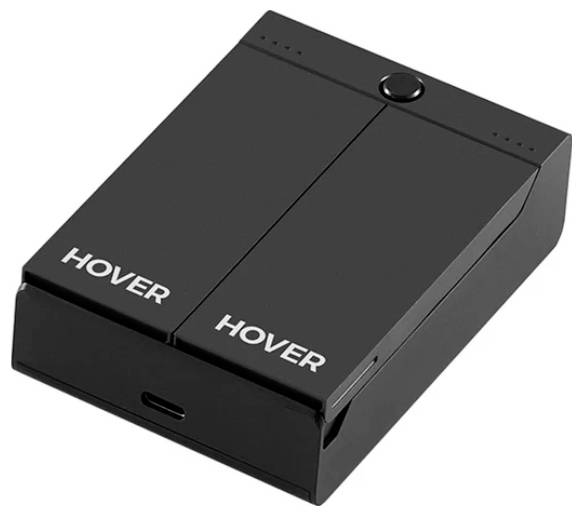 Een zwart apparaat met twee opvouwbare panelen met het label 'HOVER', voorzien van een centrale knop en een oplaadpoort.