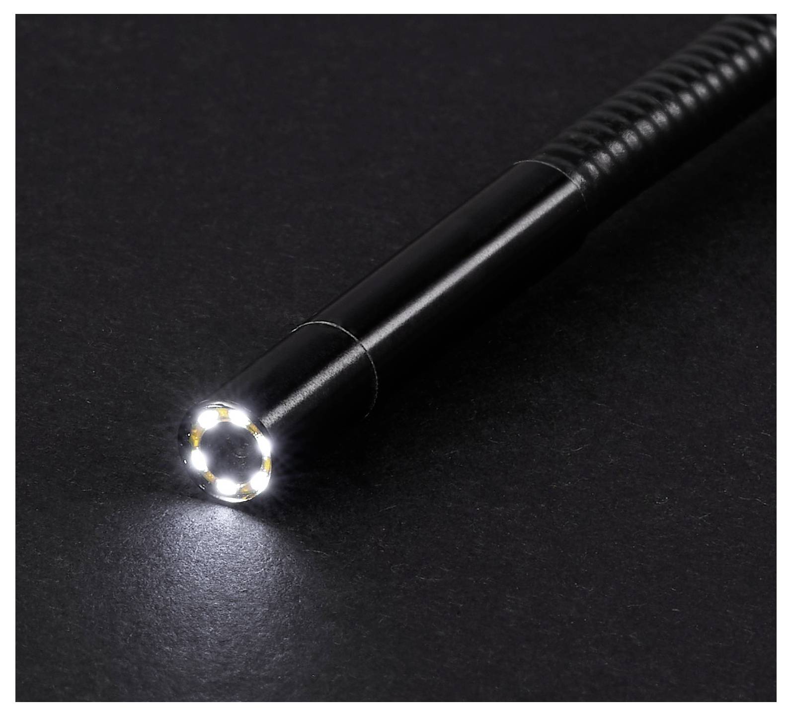Zwarte zaklamp met een helder LED-lichtstraal die op een donker oppervlak schijnt.