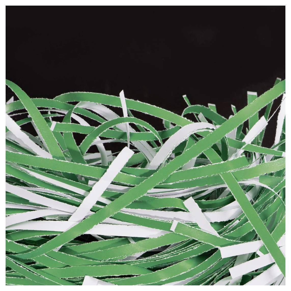 Een wirwar van gescheurde groene en witte papierstroken die in verschillende richtingen verspreid liggen tegen een zwarte achtergrond.