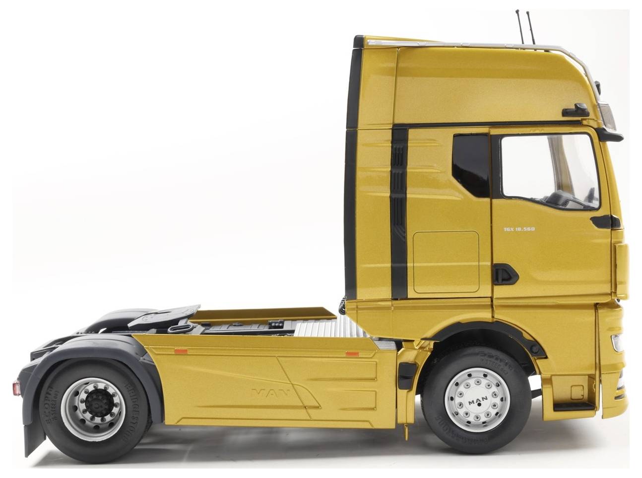 Een gele semi-vrachtwagencabine zonder aanhanger staat geparkeerd. De vrachtwagen wordt van opzij bekeken tegen een witte achtergrond, waarbij gedetailleerd ontwerp zichtbaar is.