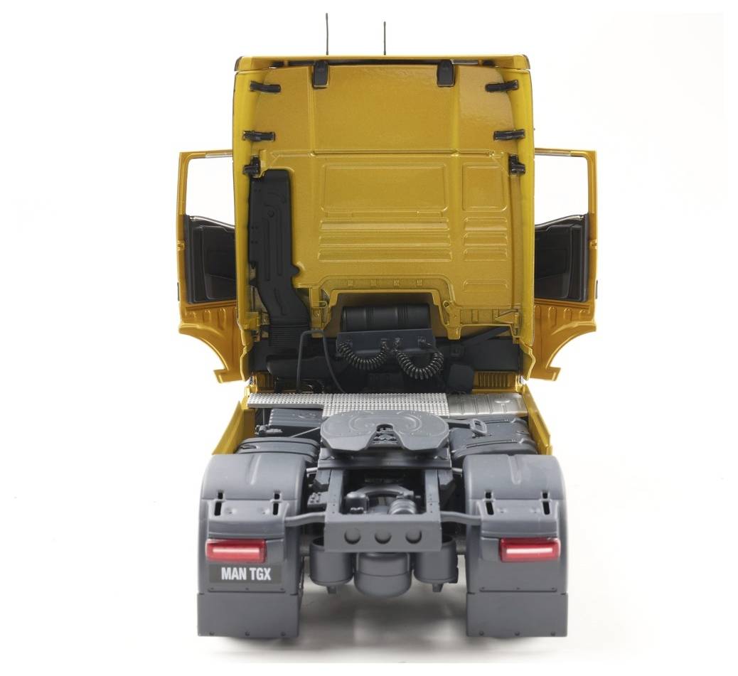 Een model van een gele MAN TGX truck cabine vanuit achteraanzicht, met open deuren en gedetailleerde componenten zoals het chassis en achterlichten.