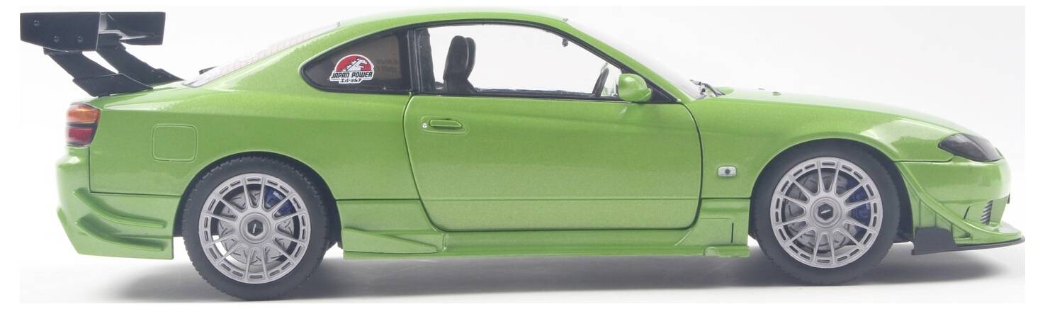 Een helder groene sportwagen met een grote achterspoiler, lage profielband en sportieve stickers op de ramen, gezien vanuit de zijkant.