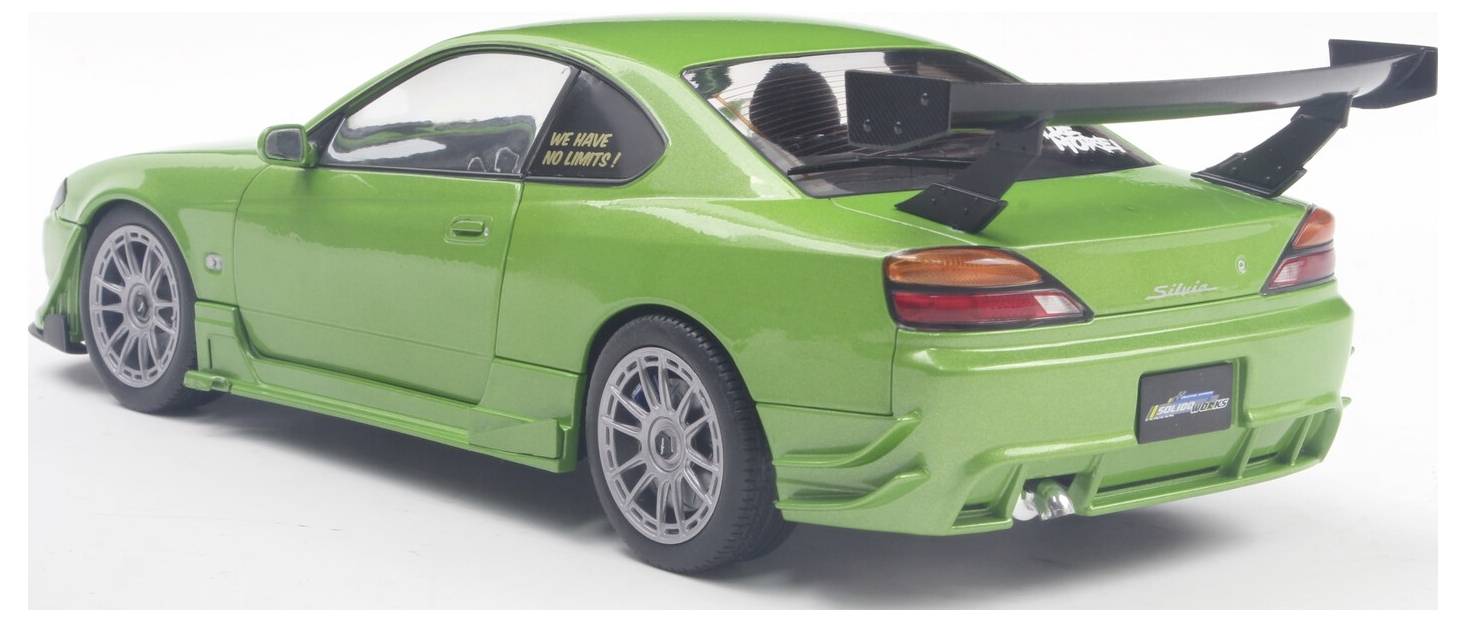 Groene sportwagen met een grote achterspoiler en custom velgen. Het achterraam heeft een sticker waarop staat: 'Wij remmen voor donuts.'