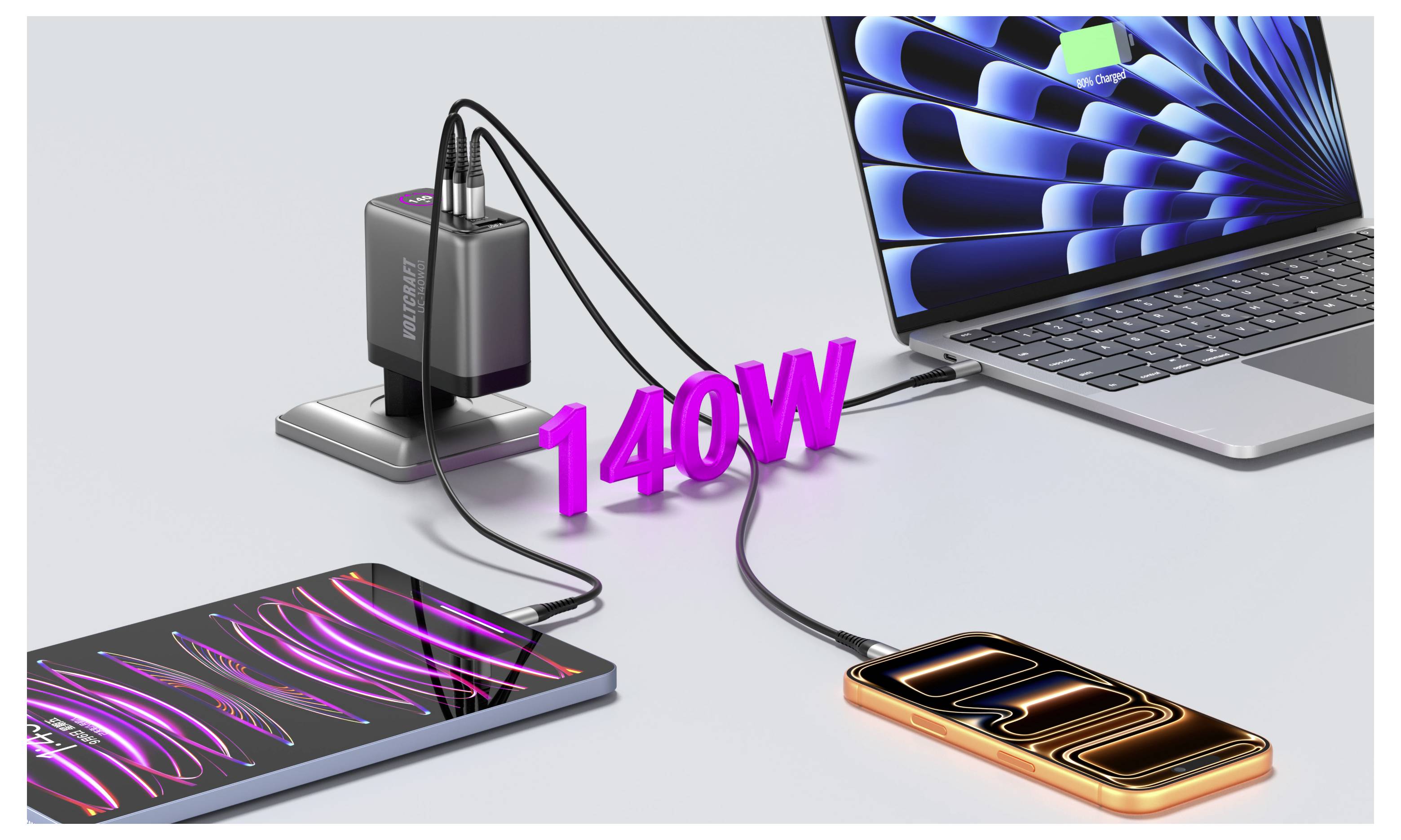 Een oplaadstation voorziet tegelijkertijd een laptop, tablet en smartphone van stroom via USB-kabels, gelabeld '140W', op een bureau.