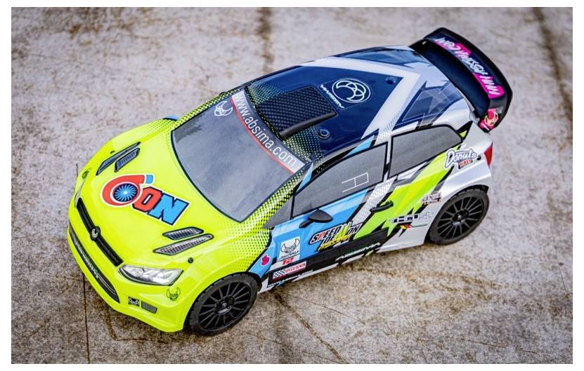 Een modelbil rally-auto met een levendige groen-, wit- en zwarte kleurstelling, voorzien van verschillende sponsorlogo's en ingewikkelde patronen op een stenen ondergrond.