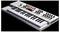Een witte toetsenbordsynthesizer met verschillende draaiknoppen en schuifregelaars, met rode en zwarte knoppen, onder een hoek geplaatst om de interface-bediening te benadrukken.