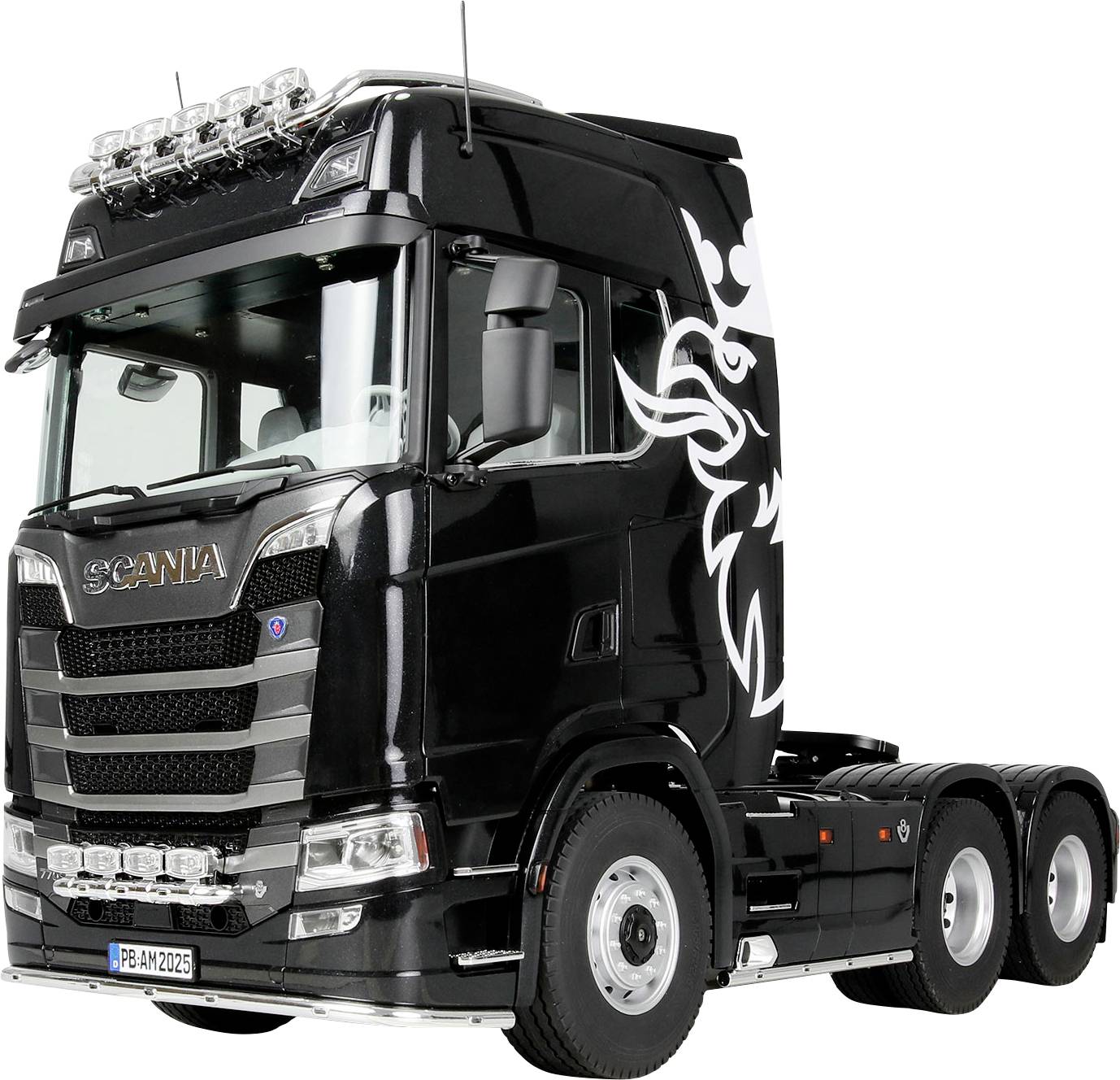 Een zwarte semi-vrachtwagen cabine met een decoratief wit ontwerp aan de zijkant, voorzien van zilveren details en meerdere lichten bovenop.