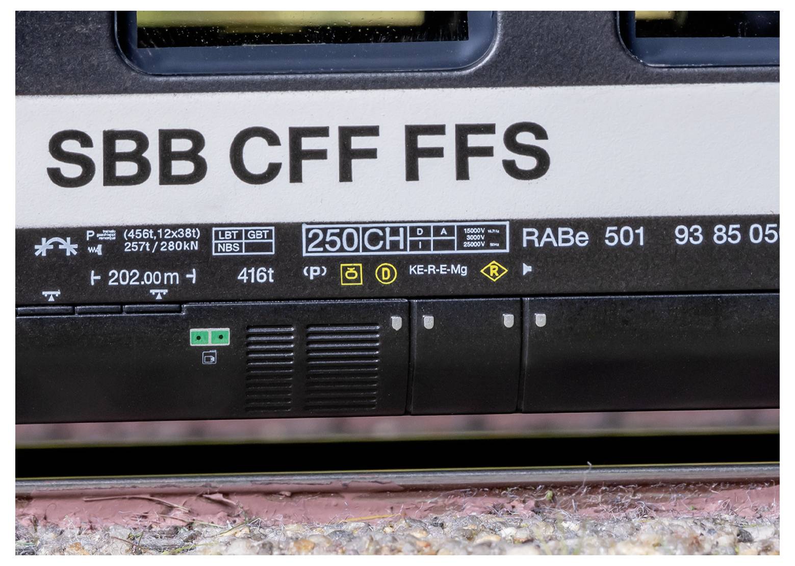 Een gedetailleerde close-up van de zijkant van een trein, waarbij verschillende technische specificaties en codes zichtbaar zijn, waaronder 'SBB CFF FFS' en 'RABe 501.'