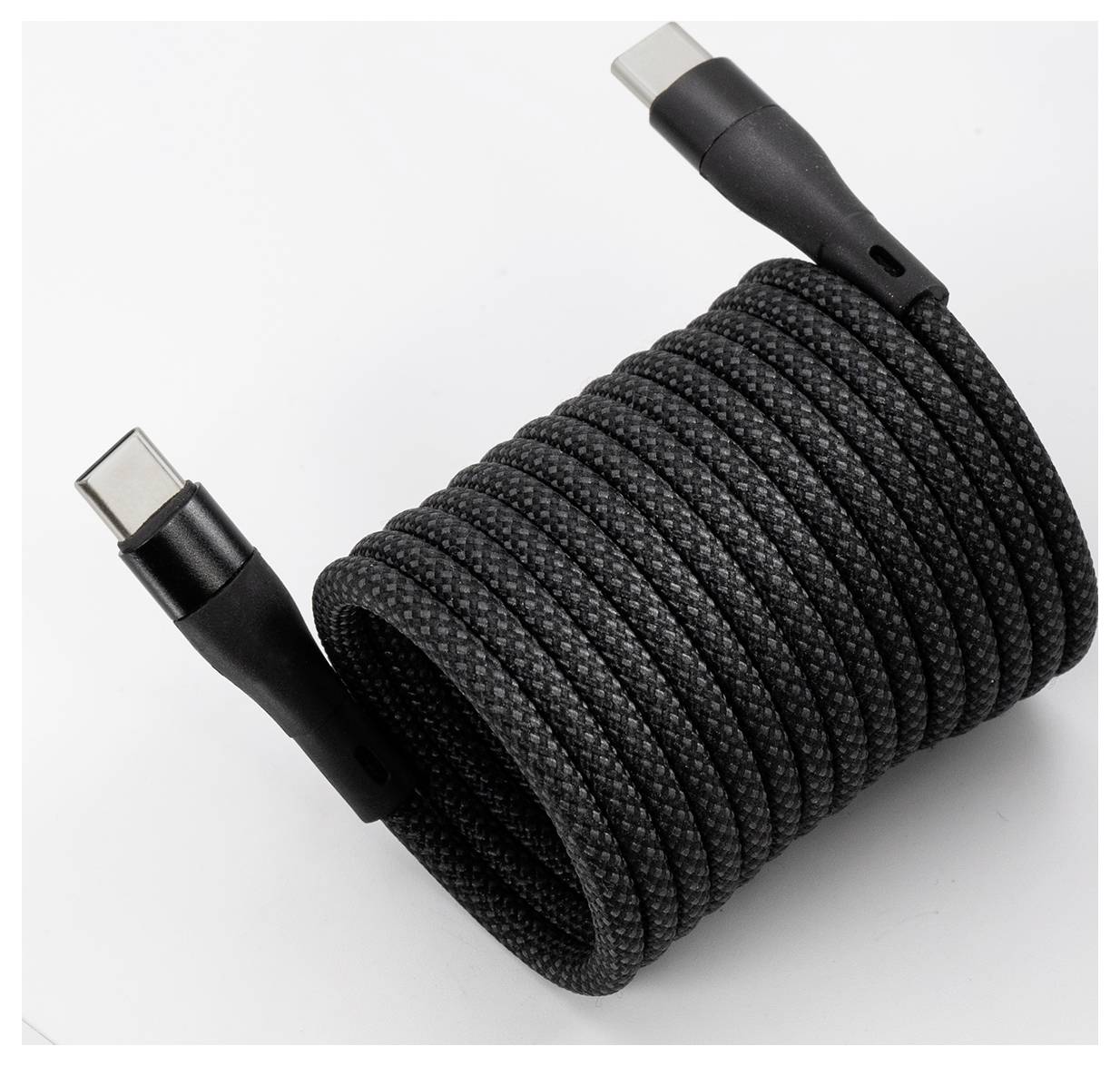 Een gecoilde zwarte gevlochten USB-C kabel met connectoren zichtbaar aan beide uiteinden.